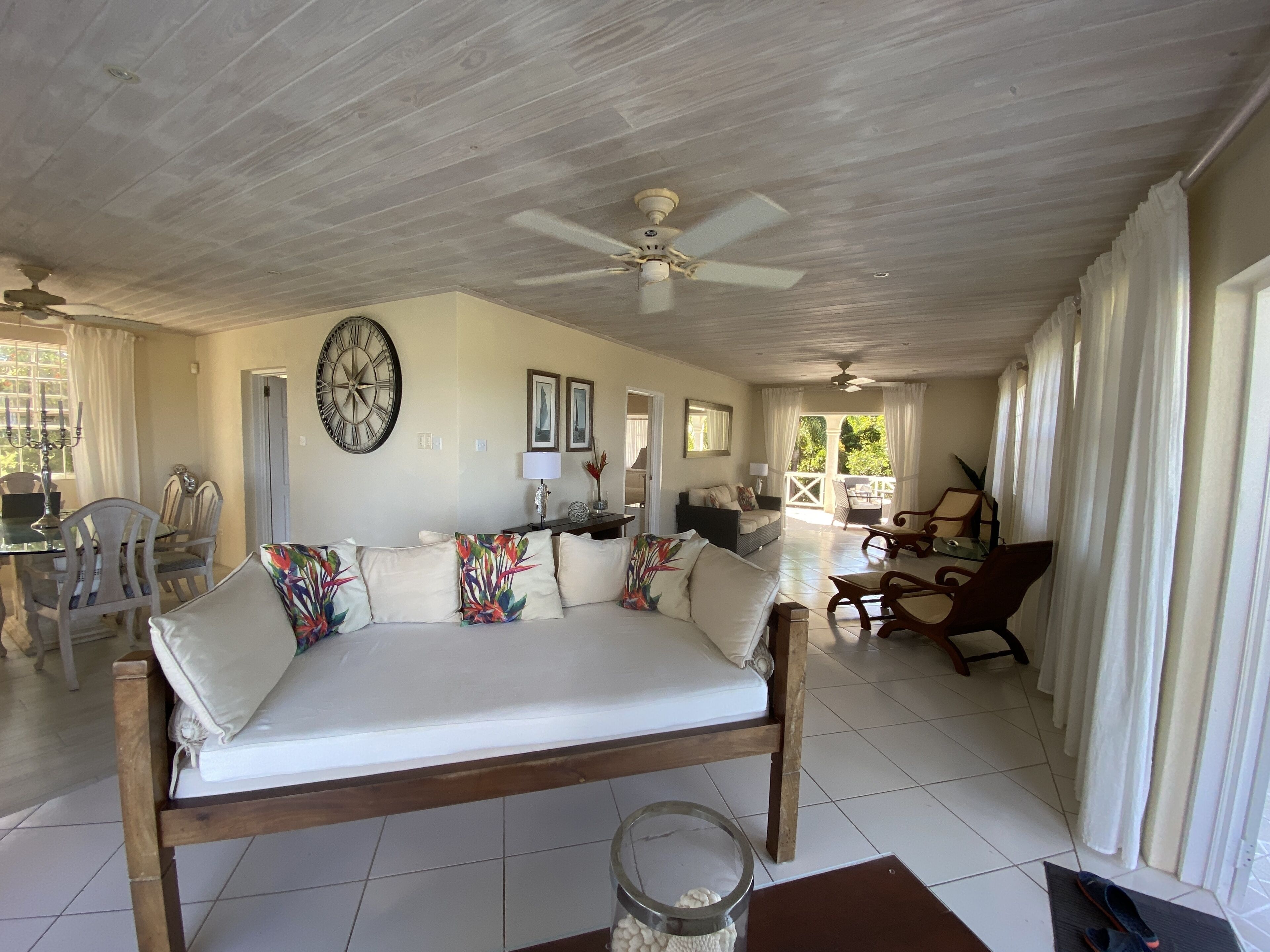 A spacious room with a large bed, a dining area with chairs and a table, and a balcony with a view.