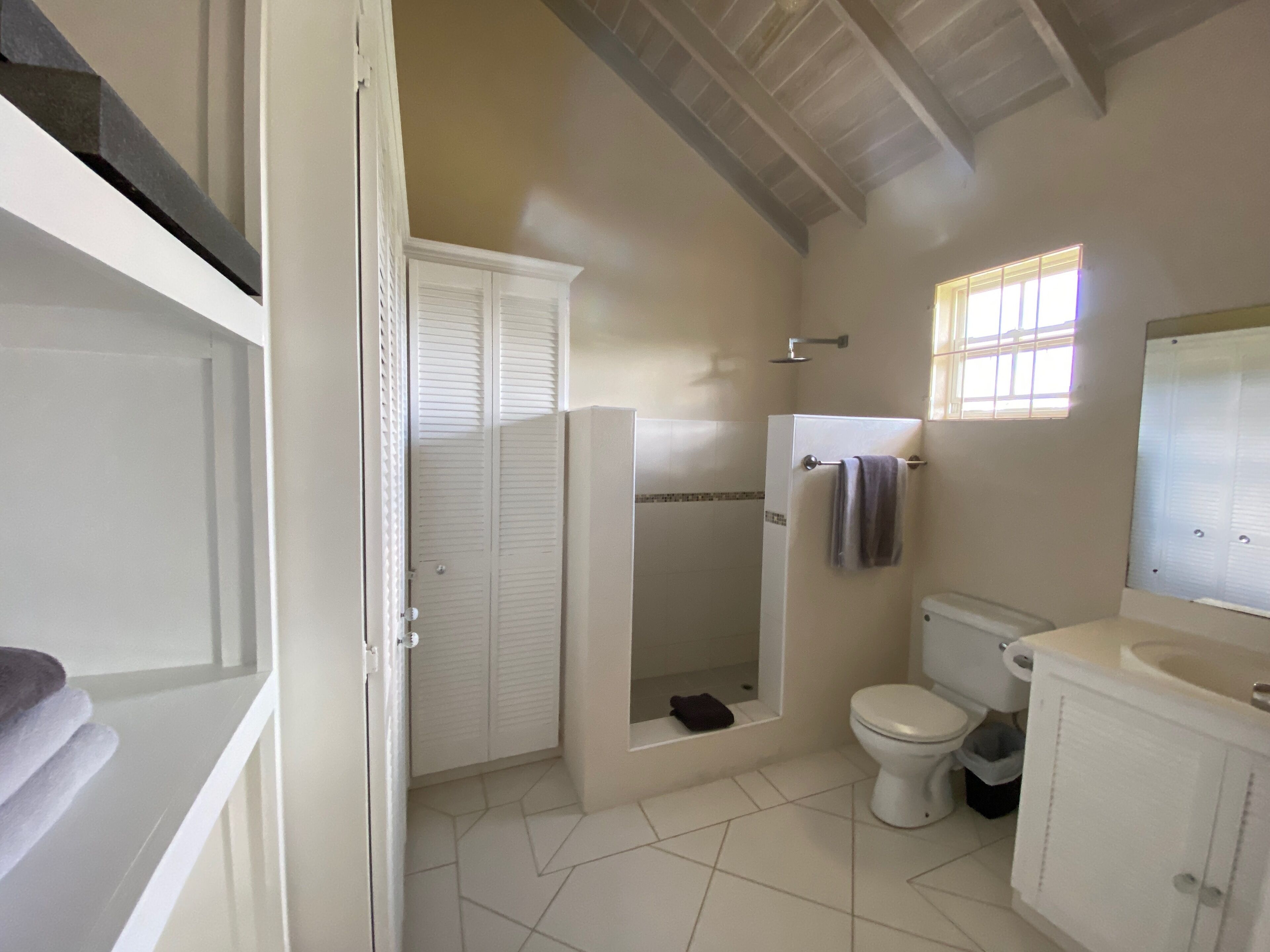 A bathroom with a shower, toilet, and sink.