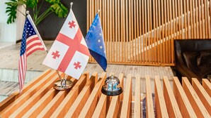 A reception desk with flags, a wooden slat wall, and a sign about Hotel Citadel Narikala's archaeological treasures. - Citadel Narikala Hotel (Tbilisi)