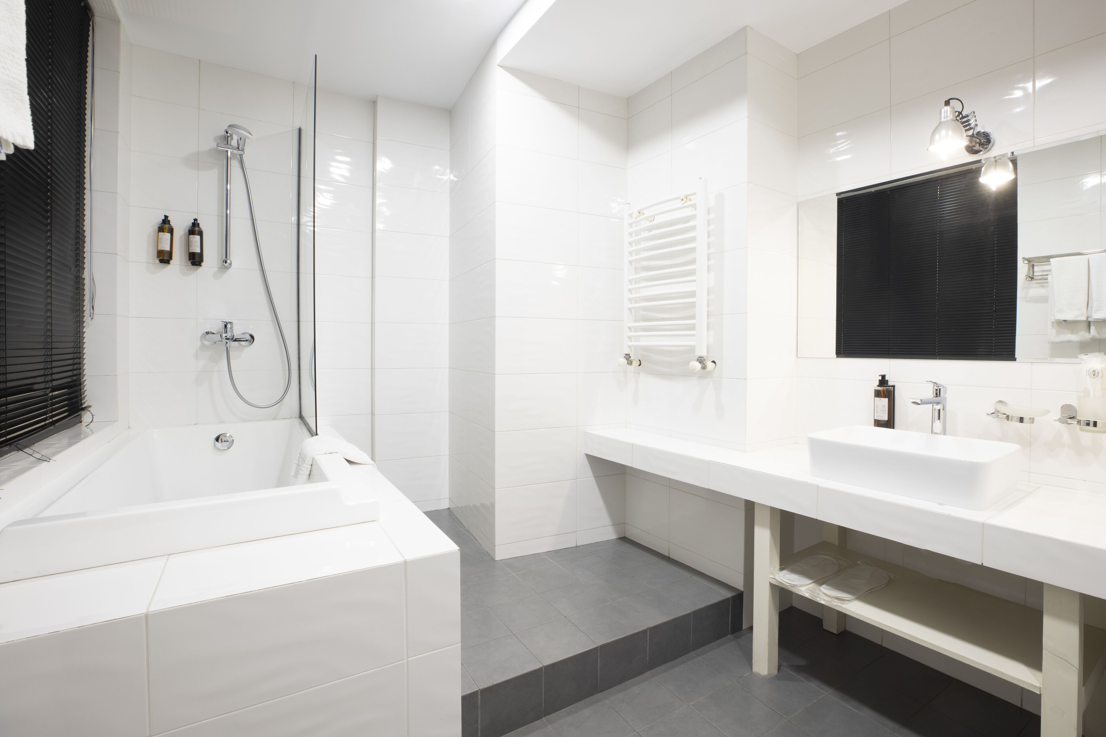 A modern bathroom with a bathtub, a shower, and a sink.