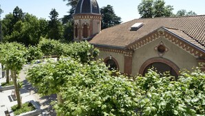 A building with a dome and arched windows, surrounded by greenery.