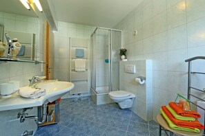 Een bad/douchecombinatie, een haardroger, handdoeken, zeep