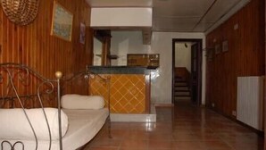 Une chambre d’hôtel avec un lit, un petit bureau et un espace de réception.
