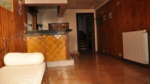 Une pièce comprenant un lit, une petite kitchenette avec une cuisinière et un mur en bois.