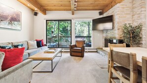 A modern living room with a sofa, armchair, and wooden coffee table. - The Gant Luxury 2BR-2BA  Suite (Aspen)