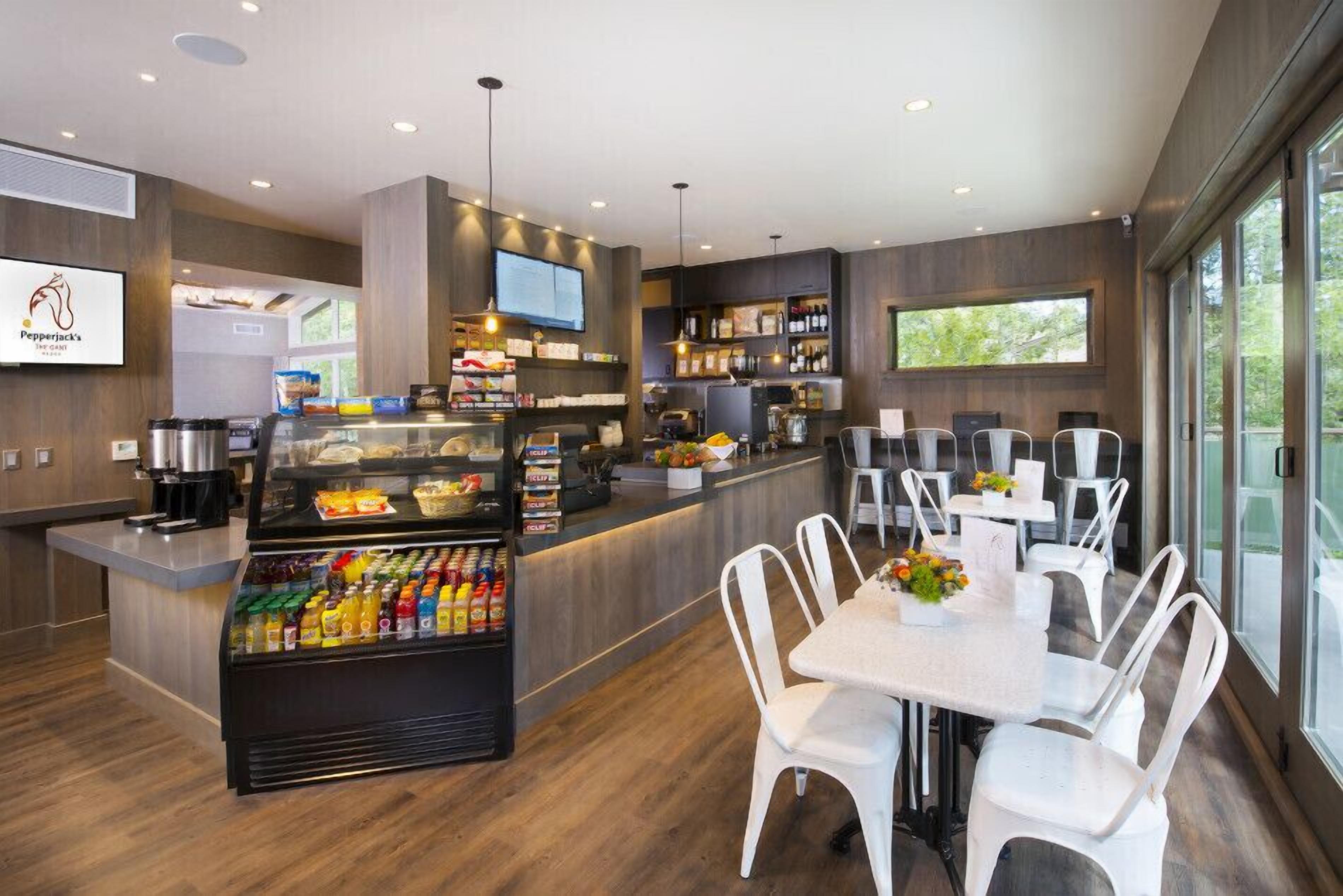 Un restaurant moderne doté d’un comptoir central, d’un espace pour s’asseoir et d’un assortiment varié de plats proposés.