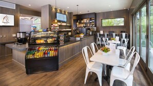 A modern restaurant with a central counter, seating area, and a variety of food items displayed. - The Gant Luxury 2BR-2BA  Suite (Aspen)