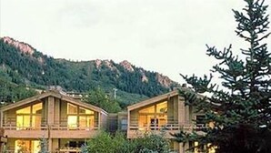 A two-story wooden lodge with large windows and balconies, surrounded by greenery and mountains. - The Gant Luxury 2BR-2BA  Suite (Aspen)