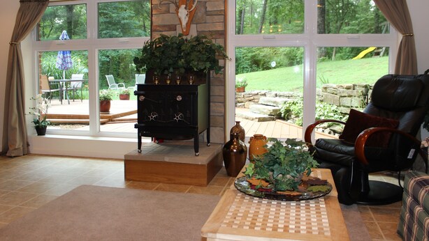 Un salón amplio con chimenea, ventanas grandes y vista al jardín.