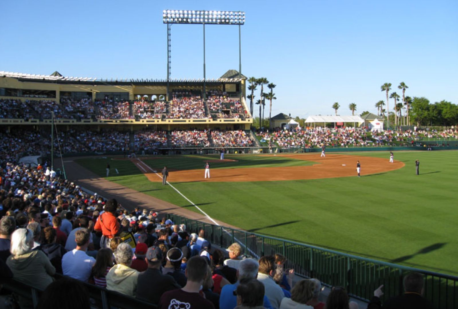 Un stade de baseball doté de plusieurs niveaux de gradins, d’un terrain en parfait état et surplombé d’un ciel dégagé.