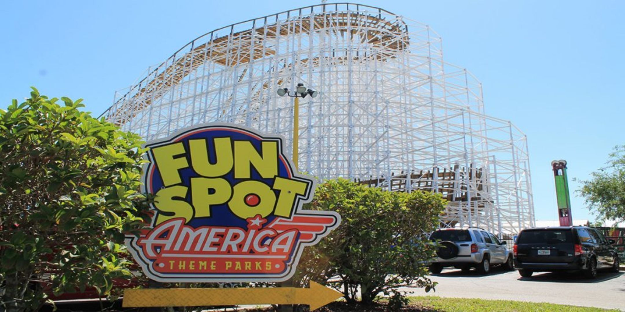 A sign for Fun Spot America Theme Parks with a roller coaster in the background.