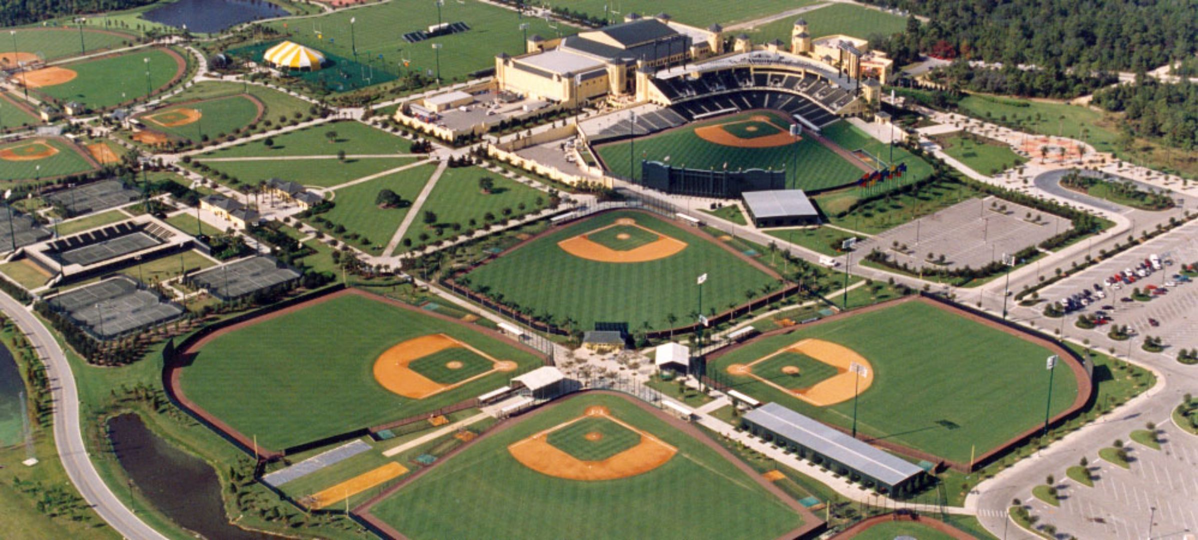 Vue aérienne d’un complexe sportif comprenant plusieurs terrains de baseball, un stade et les routes qui l’entourent.