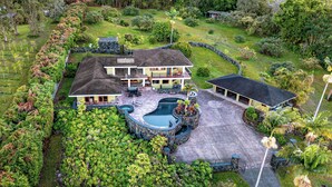 Une grande maison avec une piscine, un patio couvert et un jardin bien entretenu.
