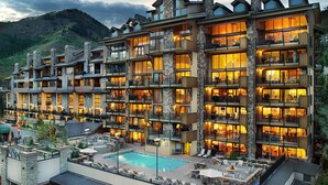 A multi-story hotel with balconies, a swimming pool, and a mountainous backdrop. - Steps to gondola! Diamond rated! Lionshead Village! Pool & Hot Tub! Landmark 116 (Vail)