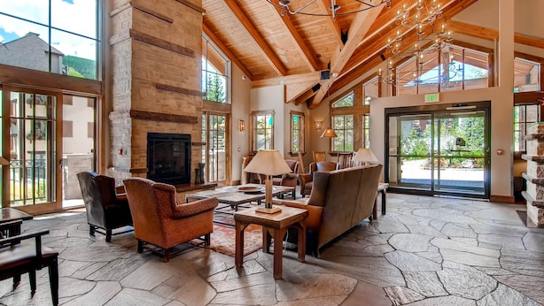 A spacious lobby with wooden beams, large windows, and a stone floor. - Steps to gondola! Diamond rated! Lionshead Village! Pool & Hot Tub! Landmark 116 (Vail)