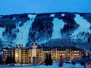Experience the grandeur of this mountain resort, featuring a striking central tower and modern architecture.