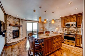 Enjoy cooking in this well-equipped kitchen with a central island, appliances, and a stone accent wall.