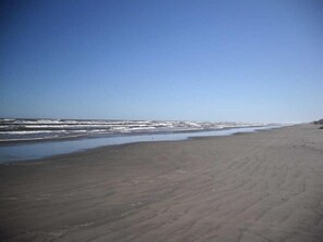 Enjoy a serene beach experience with waves gently breaking onto the shore.