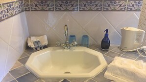 A bathroom sink with a modern faucet, a soap dispenser, and a glass of water on the countertop. - Château de Mayragues (Cahuzac-sur-Vere)