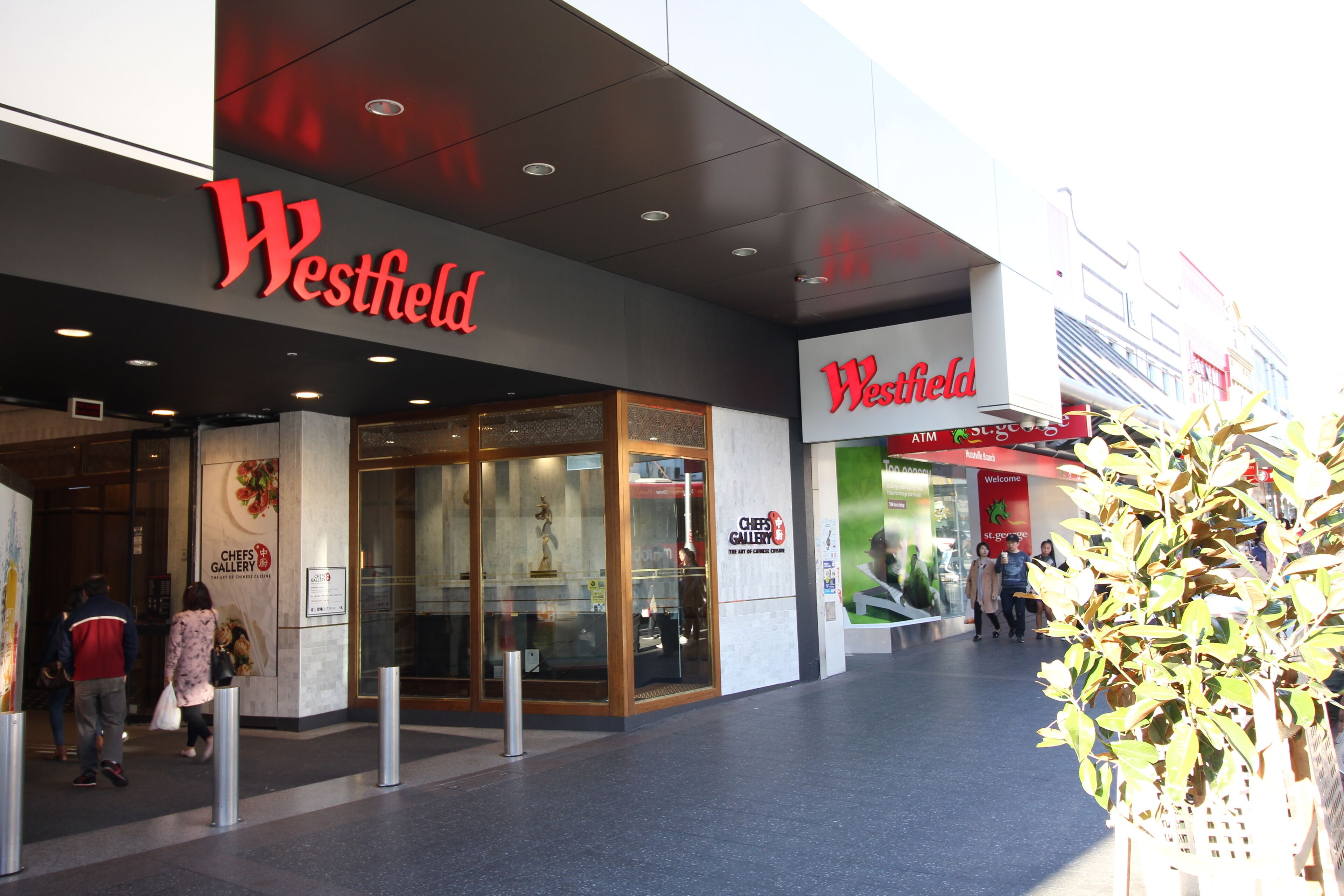 L’entrée d’un centre commercial Westfield, avec des portes en verre et une enseigne au-dessus.