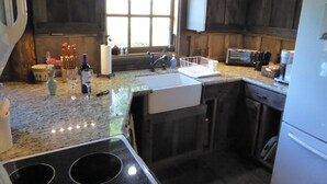 A kitchen with a granite countertop, stainless steel appliances, and wooden cabinets.