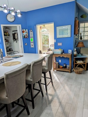 Un comedor con una mesa y sillas, un reloj en la pared y vistas al exterior.