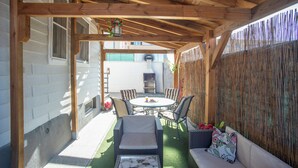 A covered patio with a wooden ceiling, a round table, and four chairs. - Casa Melchor for 9 people (Castejón)