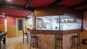 A kitchen with a brick island, bar stools, and a foosball table. - Casa Melchor for 9 people (Castejón)