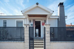 A building with a gated entrance, a sign indicating 'Casa Micher', and a 'VT' sign above the door. - Casa Melchor for 9 people (Castejón)