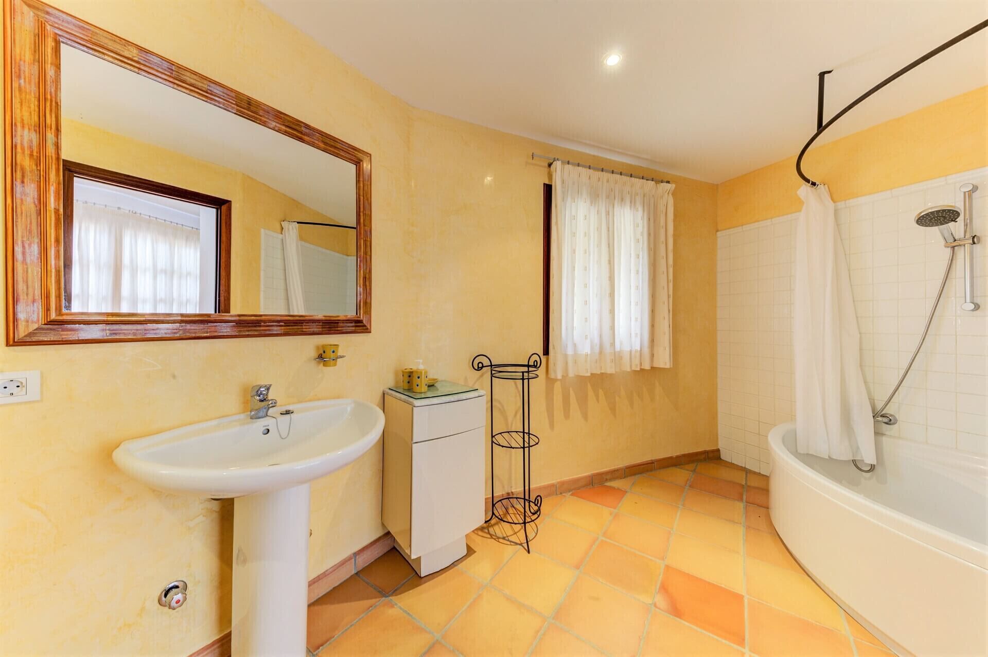 A bathroom with a sink, mirror, cabinet, and shower.