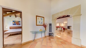 Amplia sala de estar con mesa de vidrio, sofá y mesa de comedor con sillas.