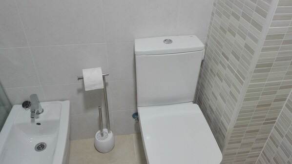 A bathroom with a toilet, sink, and a plunger. - Beachfront Apartment. 2 bedroms. (El Campello)