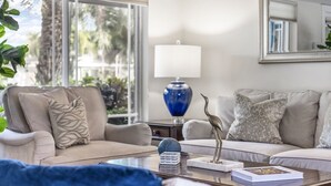 A living room with two sofas, a coffee table, a lamp, and a decorative bird statue. - Spacious WATERFRONT villa, heated salt water pool, very central, beach 5 min (Oakland Park)