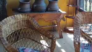 A room with a yellow wall, a map, and three pottery items on a shelf.