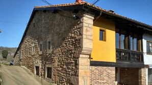 A two-story stone building with a yellow upper section and a brick lower section.