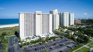 Un hôtel de grande hauteur, avec de nombreux étages, un parking et une vue sur la plage.
