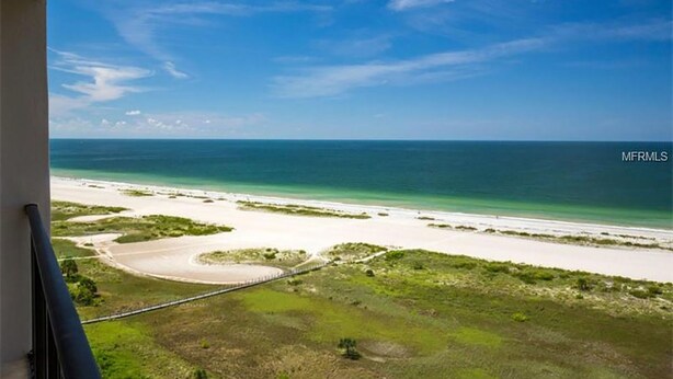 Une vue sur la plage, avec un ciel dégagé, une plage de sable et un petit plan d’eau.