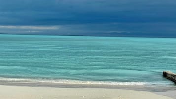 A beach with clear turquoise water and a sandy shore.