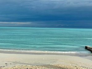 Une plage à l’eau turquoise et limpide, bordée d’un rivage sablonneux.