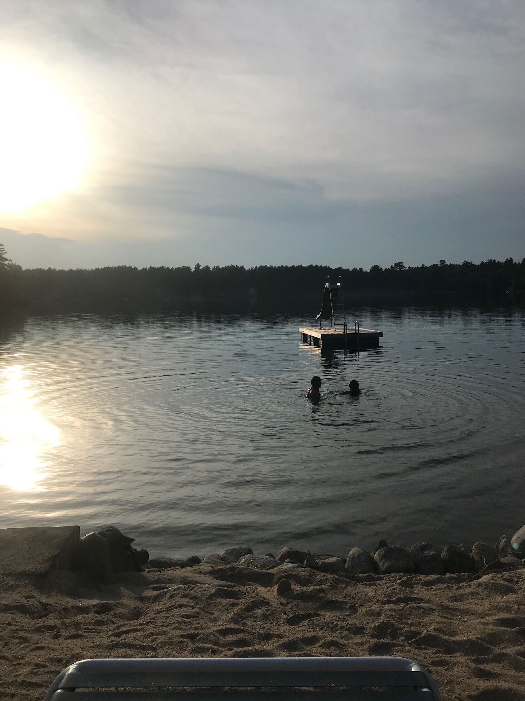 Un lago tranquilo con un muelle de madera que se adentra en el agua.