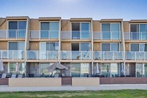 Un hôtel à plusieurs étages doté de balcons, de coins salon extérieurs et de grandes fenêtres.