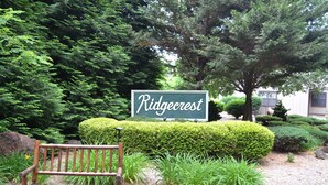 Eine Bank in einer angelegten Grünfläche mit einem Schild, auf dem 'Ridgecrest' steht.