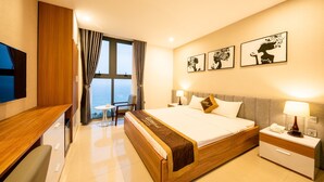 Una habitación de hotel con cama, mesita de noche, lámpara y televisión.