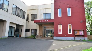 A building with a red and white facade, large windows, and a visible entrance.
