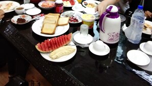 Una mesa de comedor con varios platos, una botella de agua y un termo.