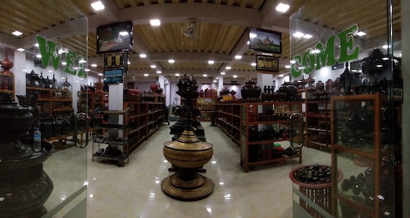 A well-lit store with glass display cases filled with pottery and decorative items.