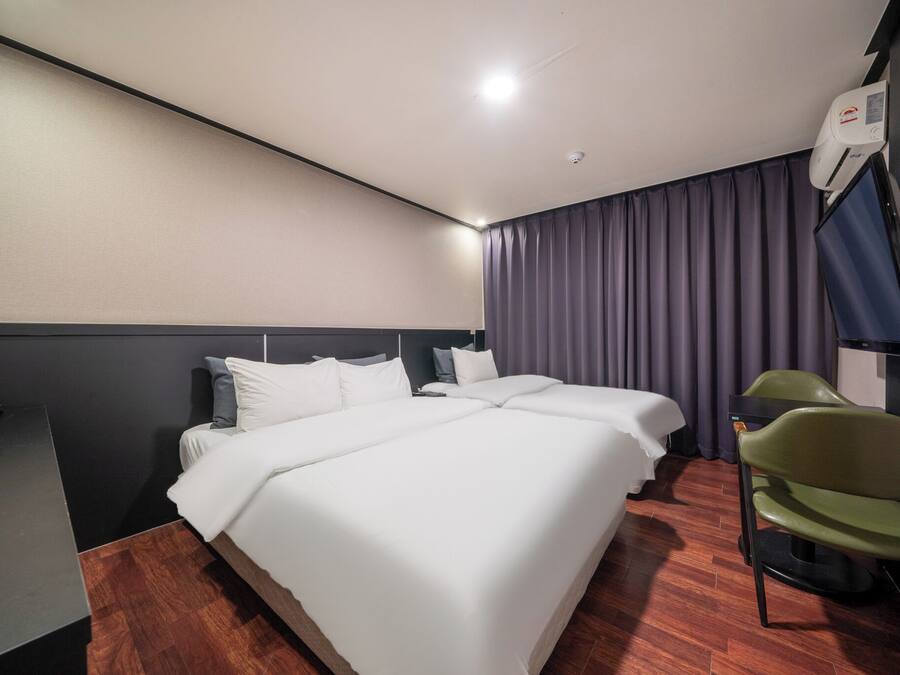 Una habitación de hotel con una cama grande, un escritorio y una silla.
