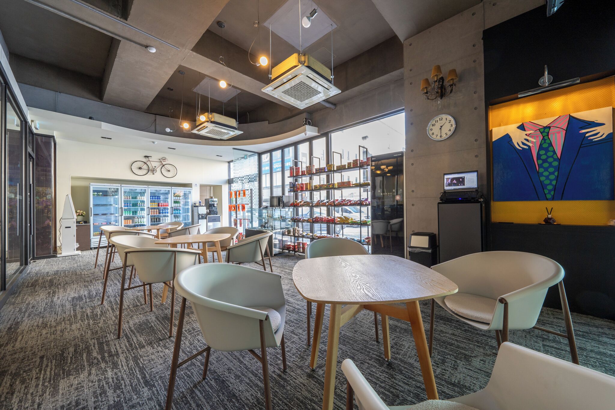 A modern interior with seating areas, a bookshelf, and a bicycle mounted on the wall.