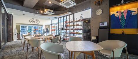 A modern interior with seating areas, a bookshelf, and a bicycle mounted on the wall.