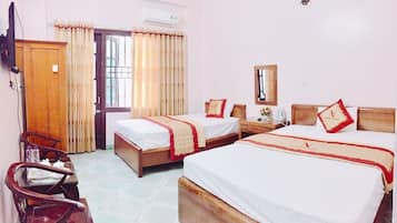 A hotel room with two beds, a desk, a chair, and a wardrobe.